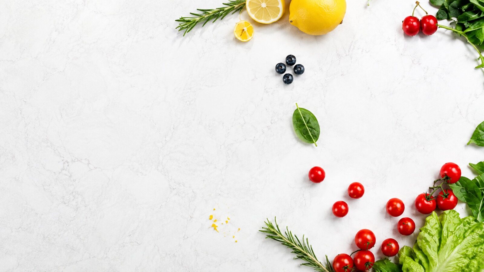 Fresh fruit and vegetables on a white stone surface